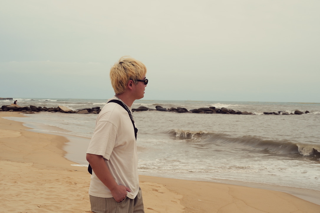 Xinyu Guan walking beside the sea