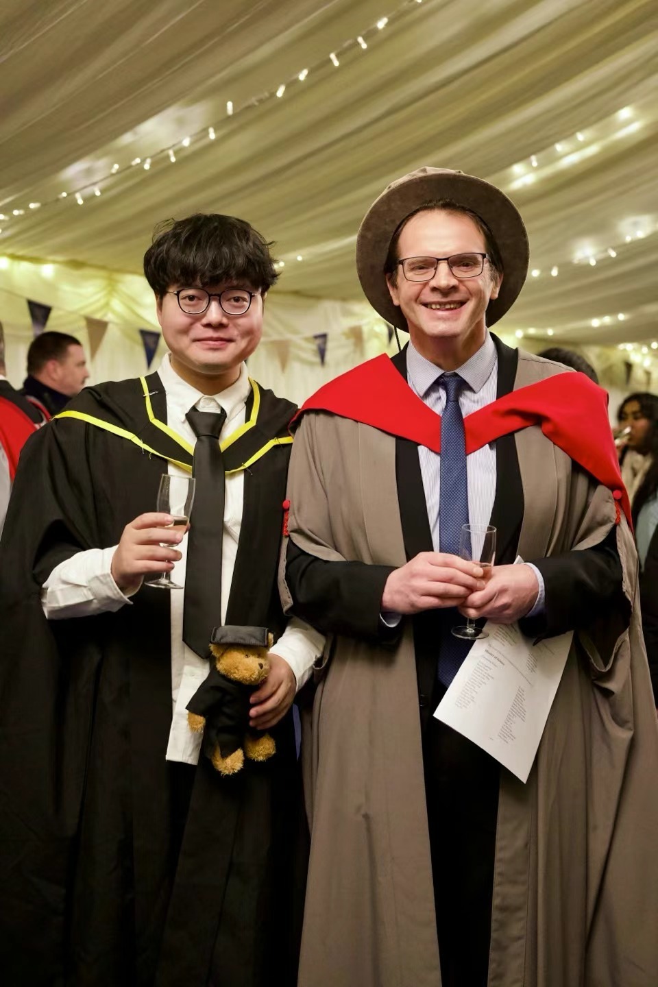 Xinyu Guan and another academic in ceremonial robes at a graduation reception